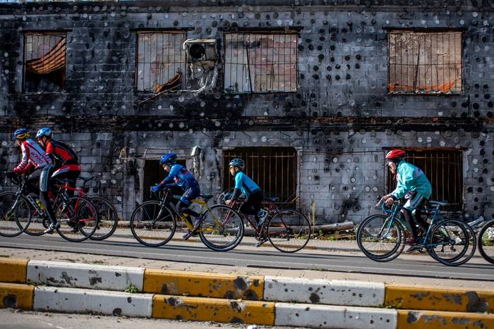 Тренировка велосекции ДЮСШ около разрушенного торгового центра Жираф. Следы от взрывов остались даже на бордюрах в Ирпени.